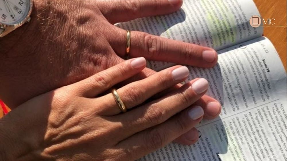 mãos em cima de uma biblia, mão feminina e masculina